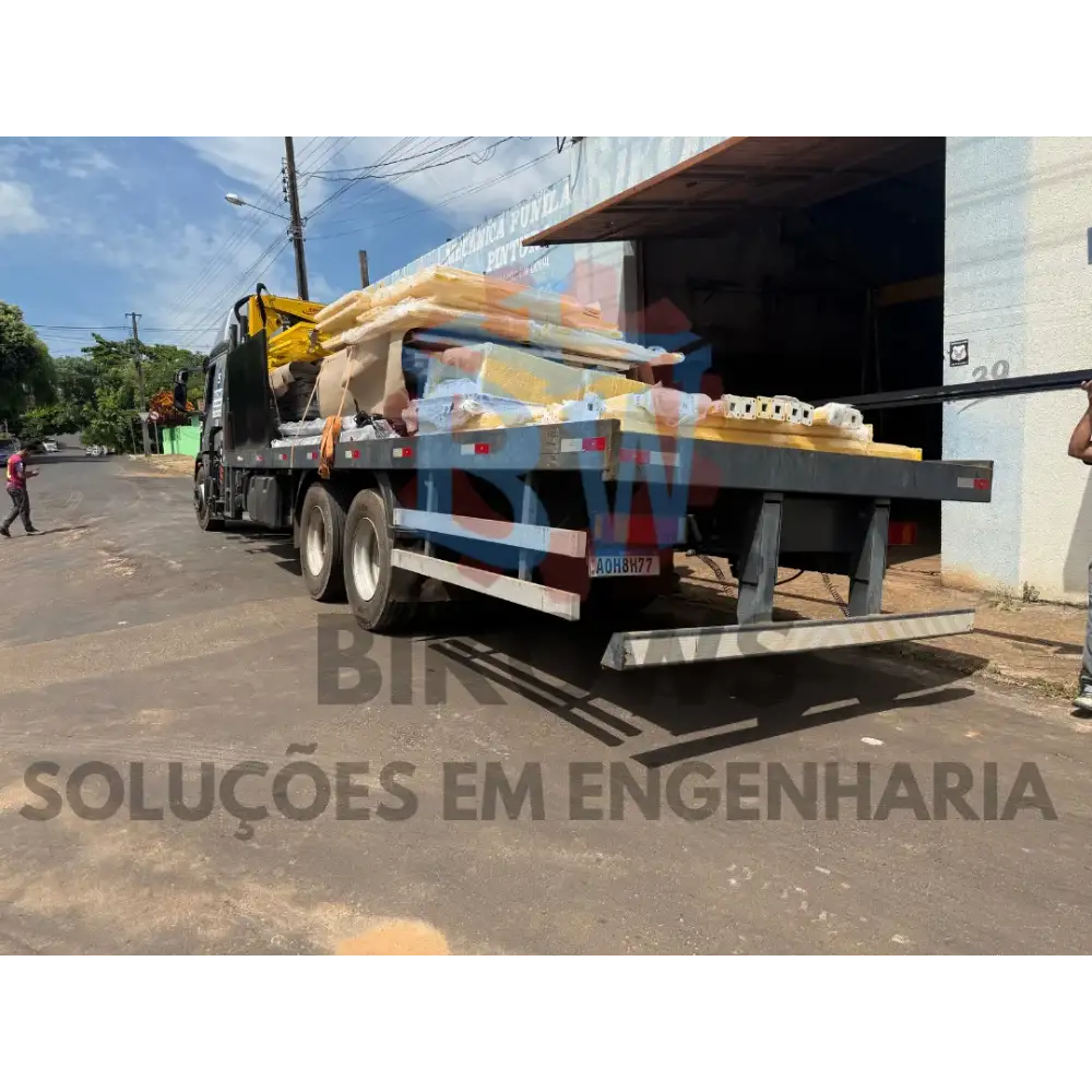 Equipe carregando materiais de obra em caminhão com empilhadeira