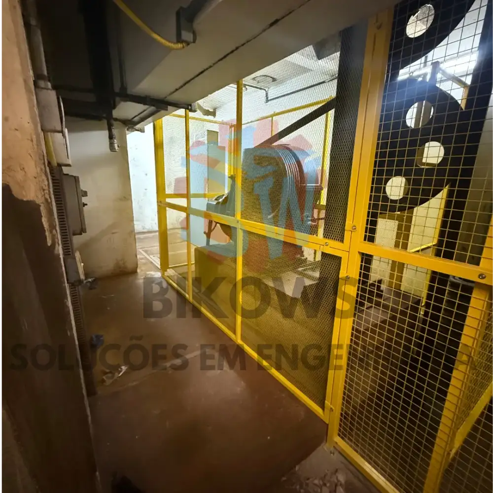 Proteção mecânica em malha amarela instalada em equipamento industrial